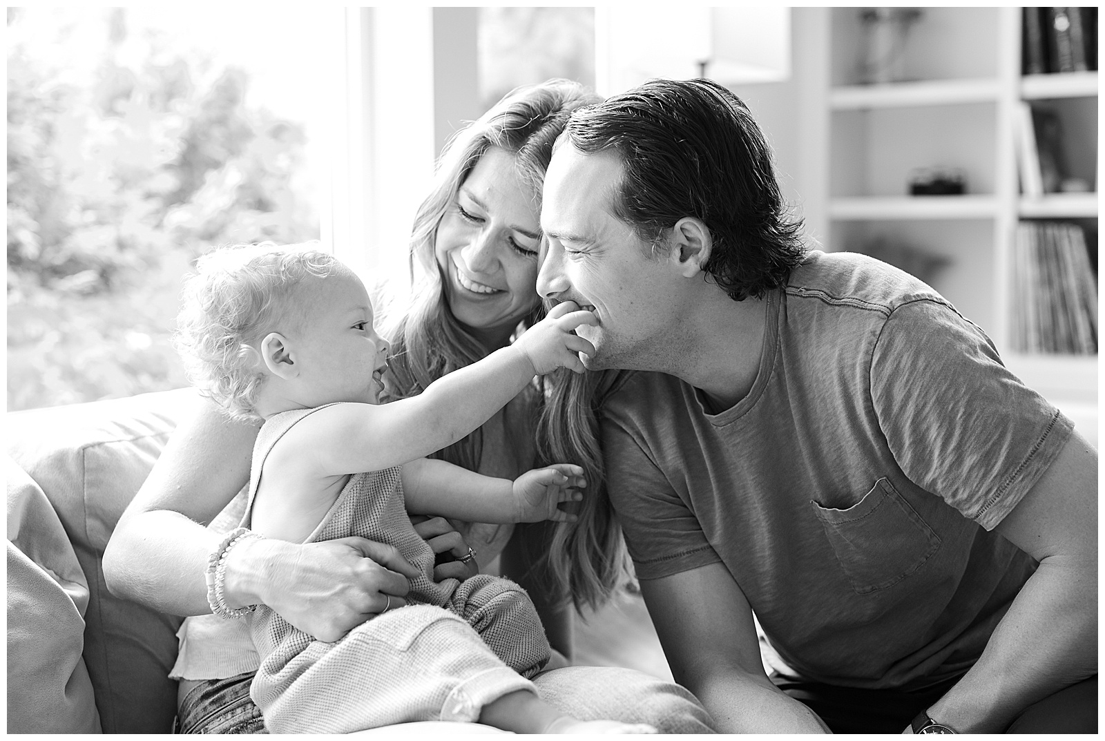 Family of three with a one year old being photographed for in home milestone session.