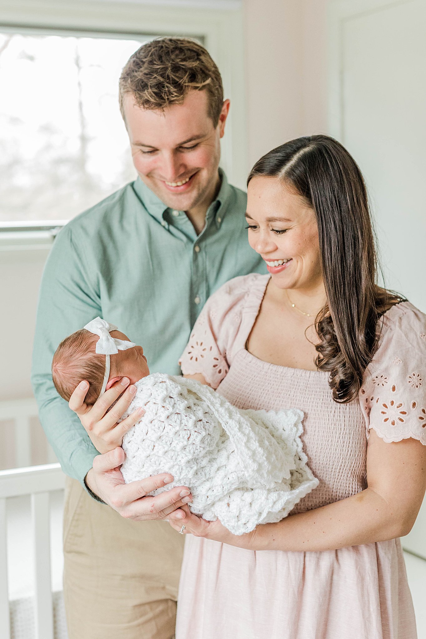 Dad and mom holding daughter at newborn photo session