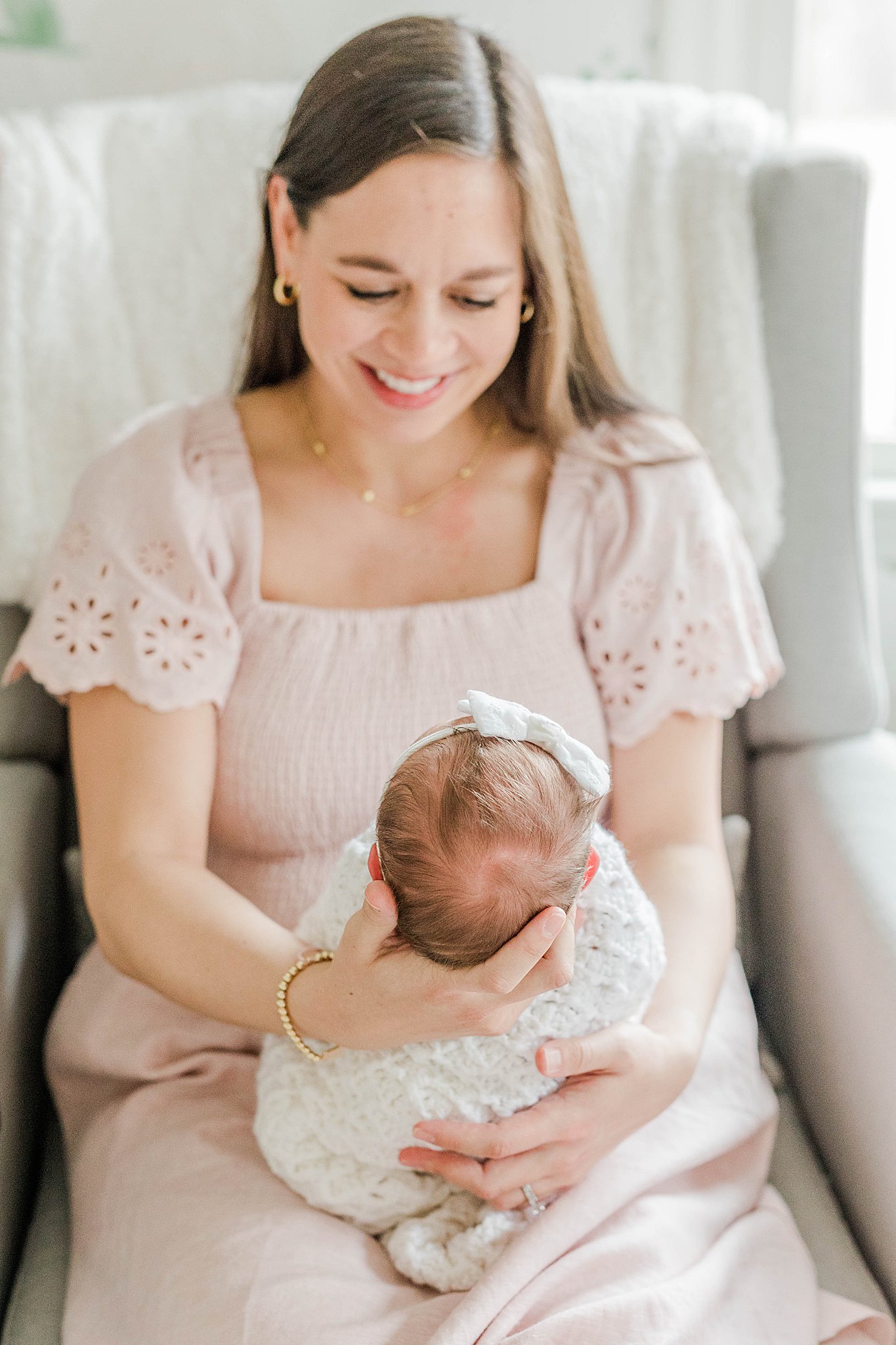 Mom holding daughter at newborn photo session