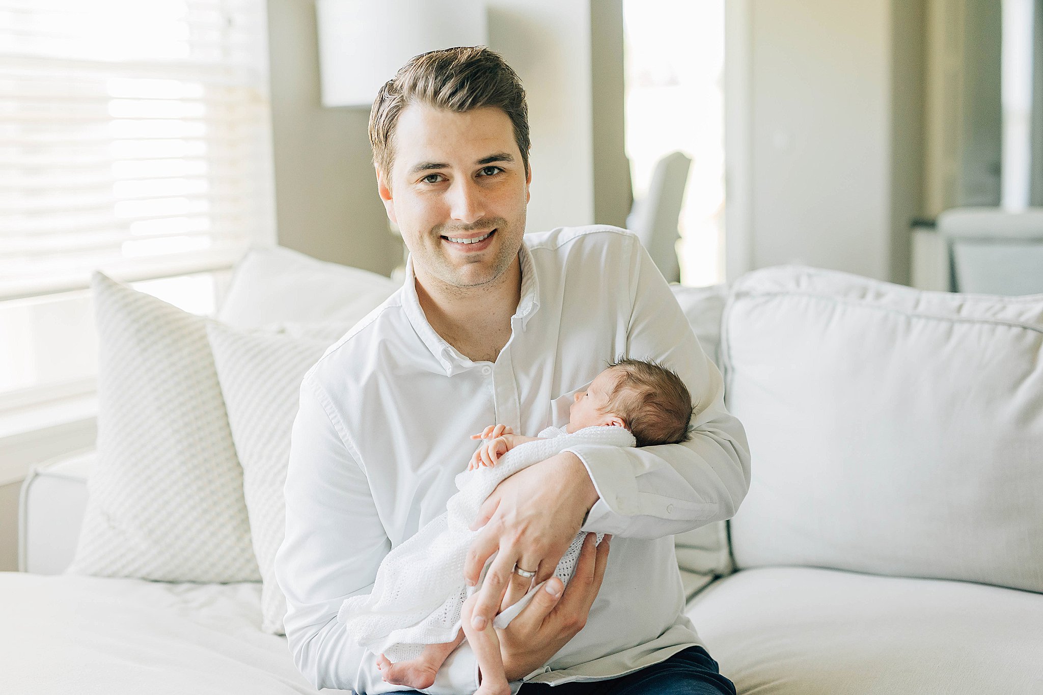 Dad holding baby during newborn photos.