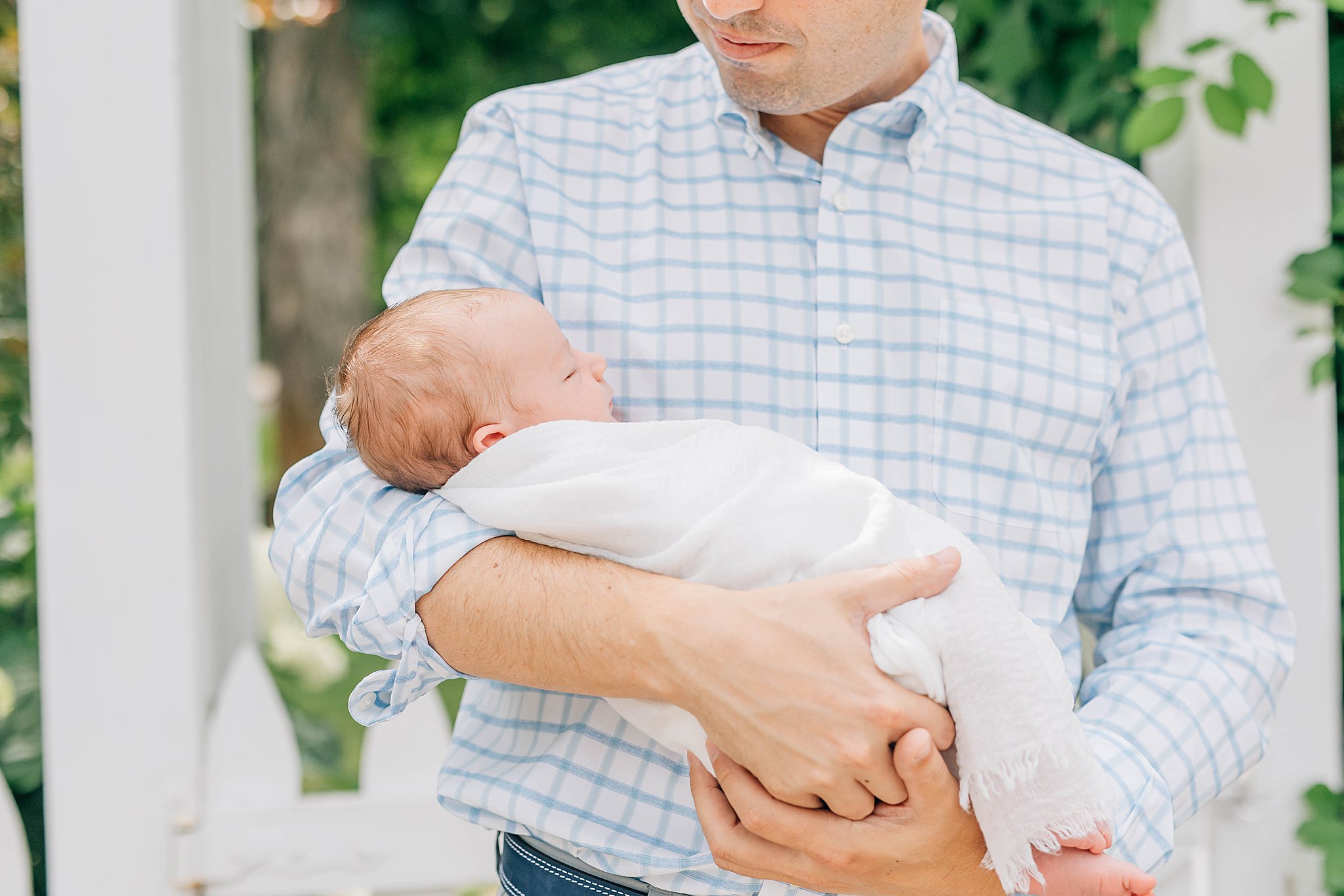Outdoor newborn photos with dad holding baby.