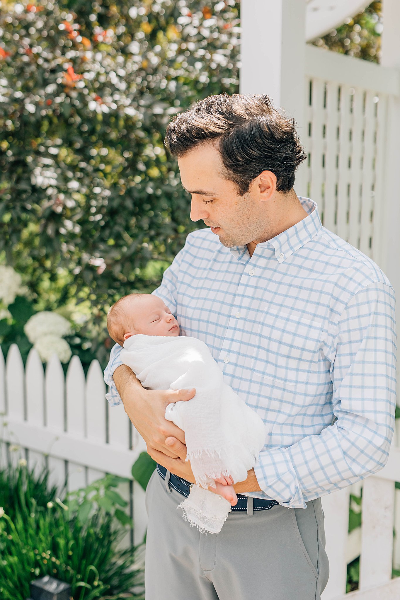 Outdoor newborn photos with dad holding baby.