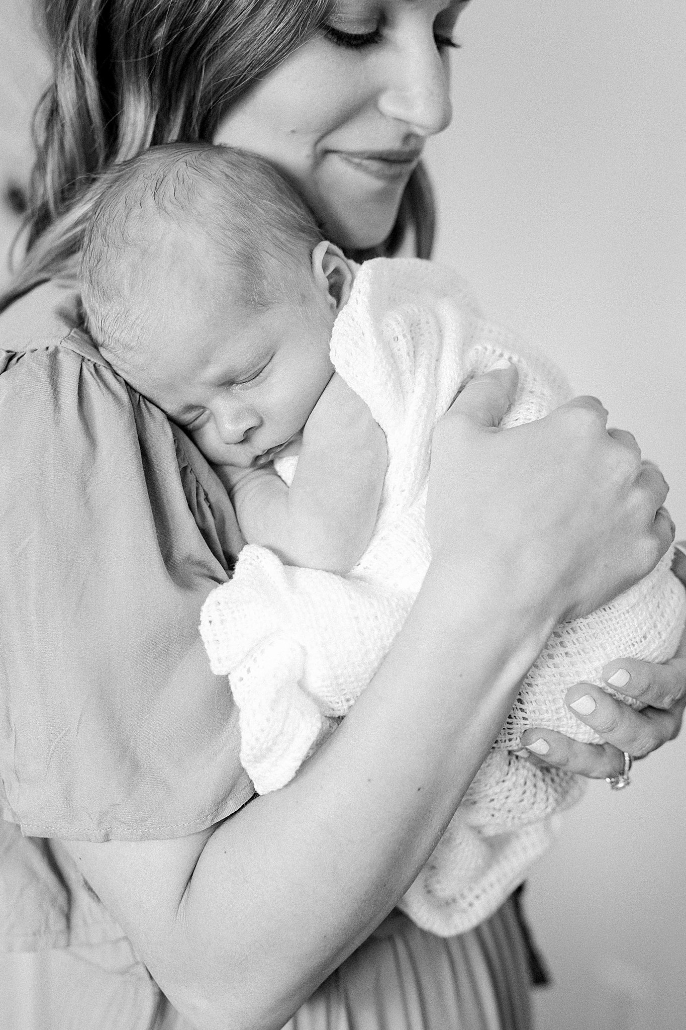 Mom holding newborn during session.