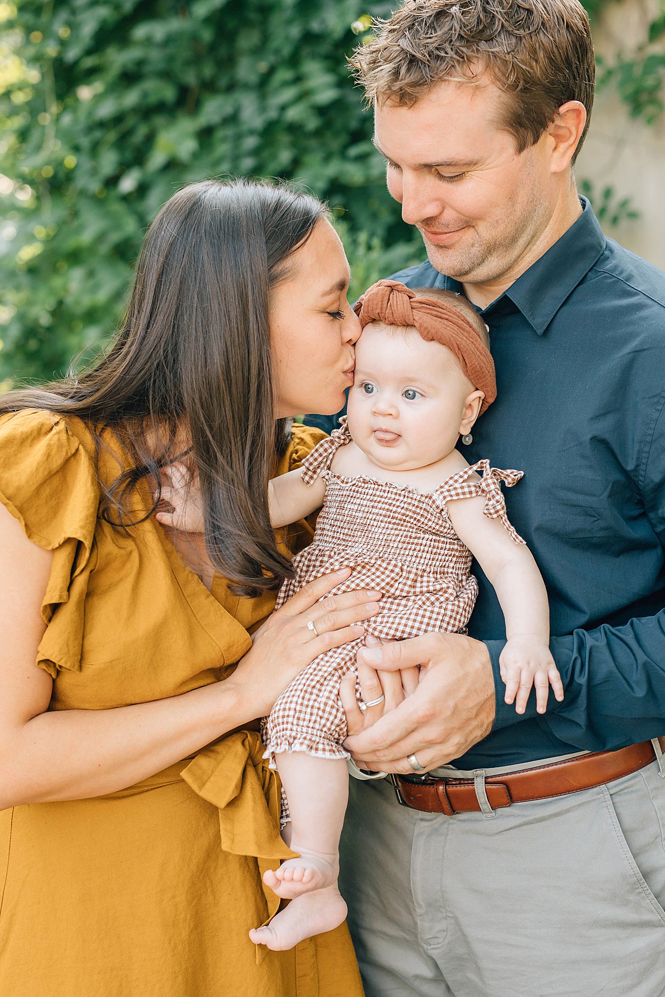 Mom kissing baby on cheek during family pictures in Chaska.