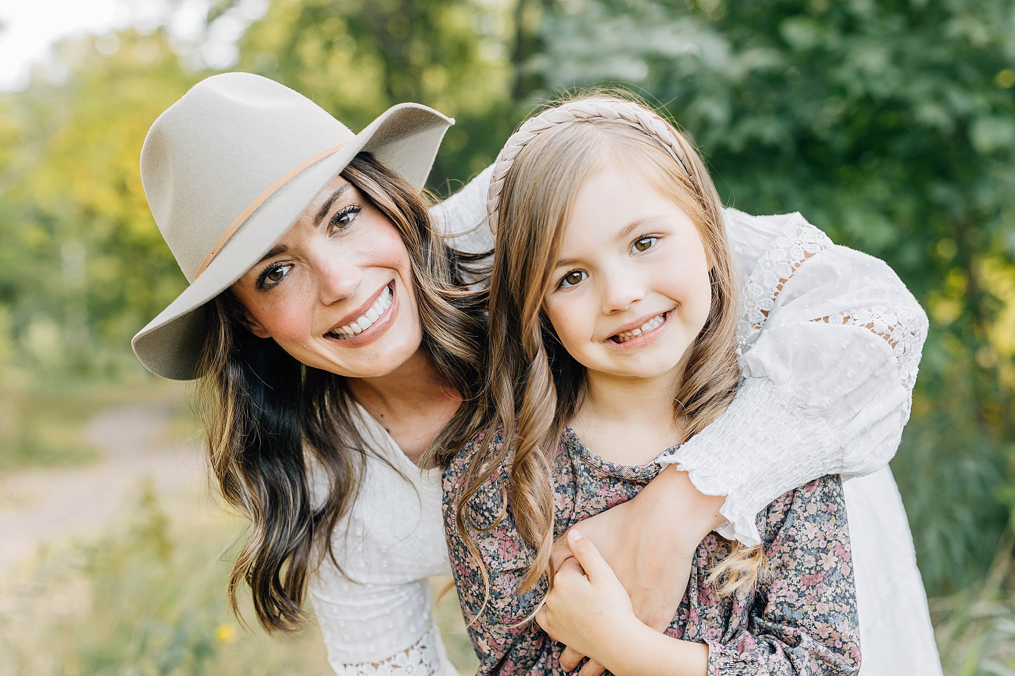 Mom and daughter smiling during family of four fall pictures.