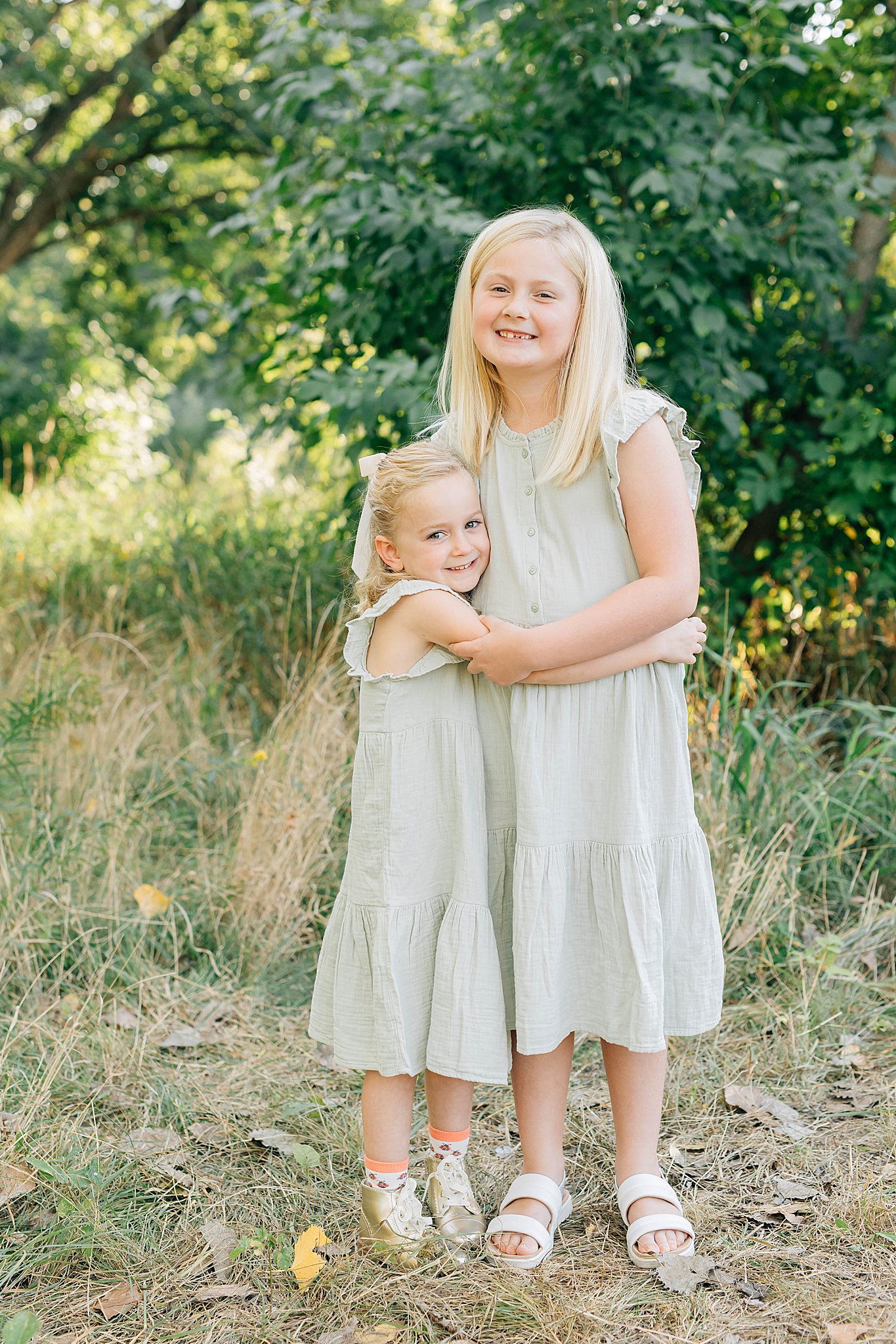 Two girls smiling and holding eachother during Edina family photography.