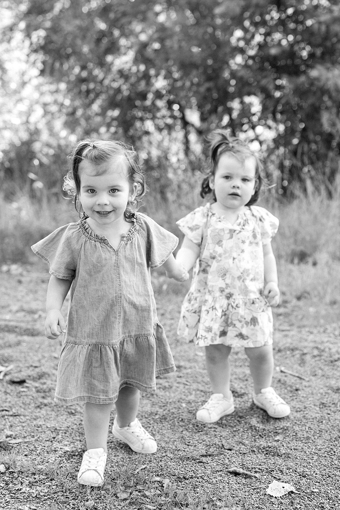 Girls holding hands during family pictures with twins