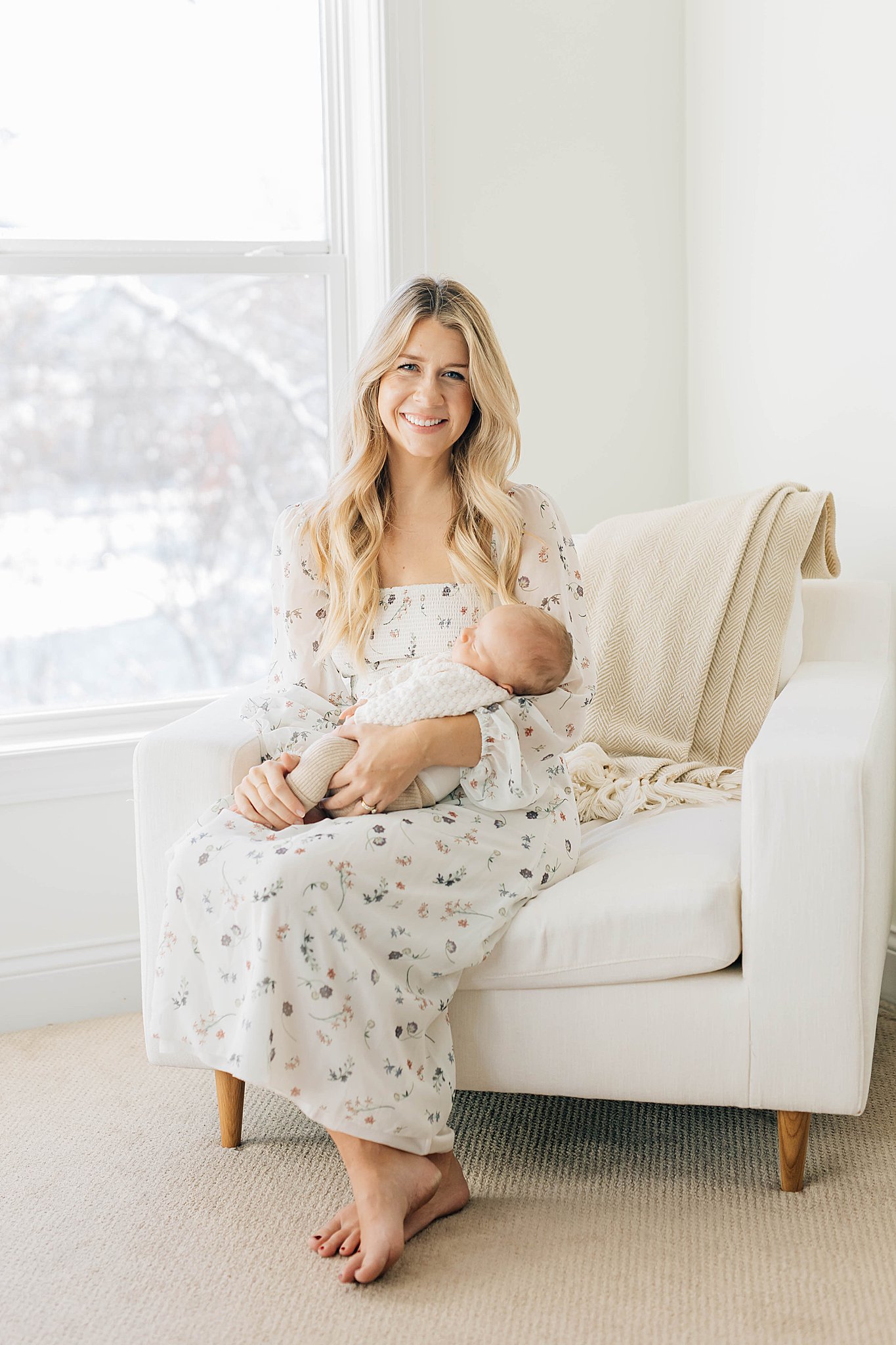 Mom holding newborn, with mom wearing long dress for outfit for newborn photos. 