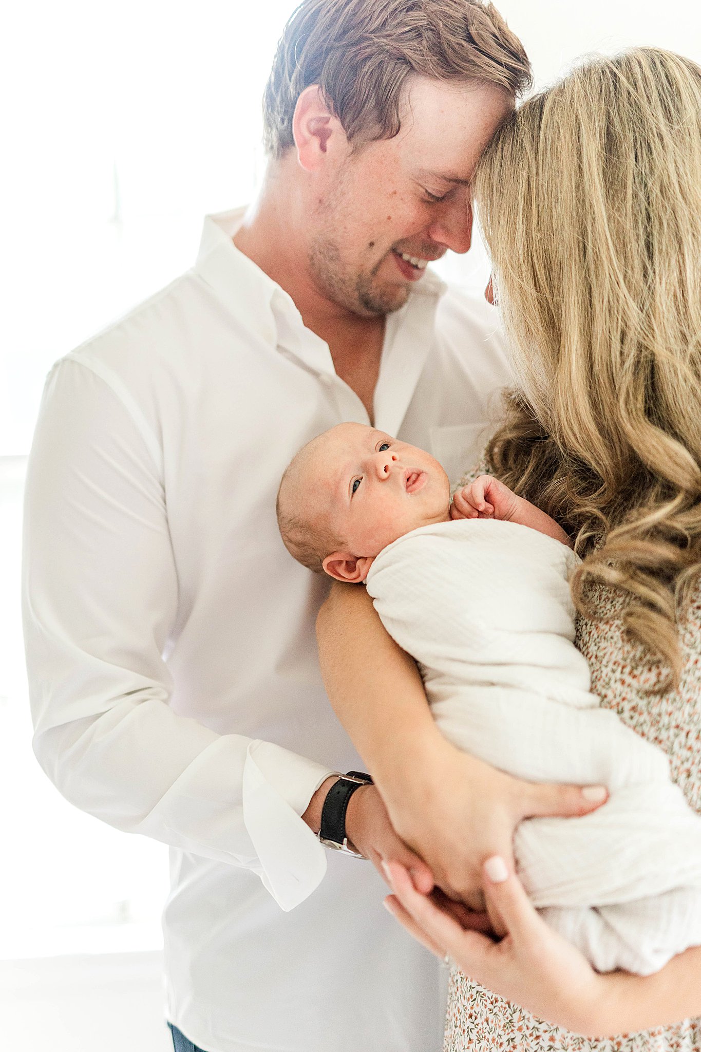 Mom and dad holding baby during MN newborn photographer session.