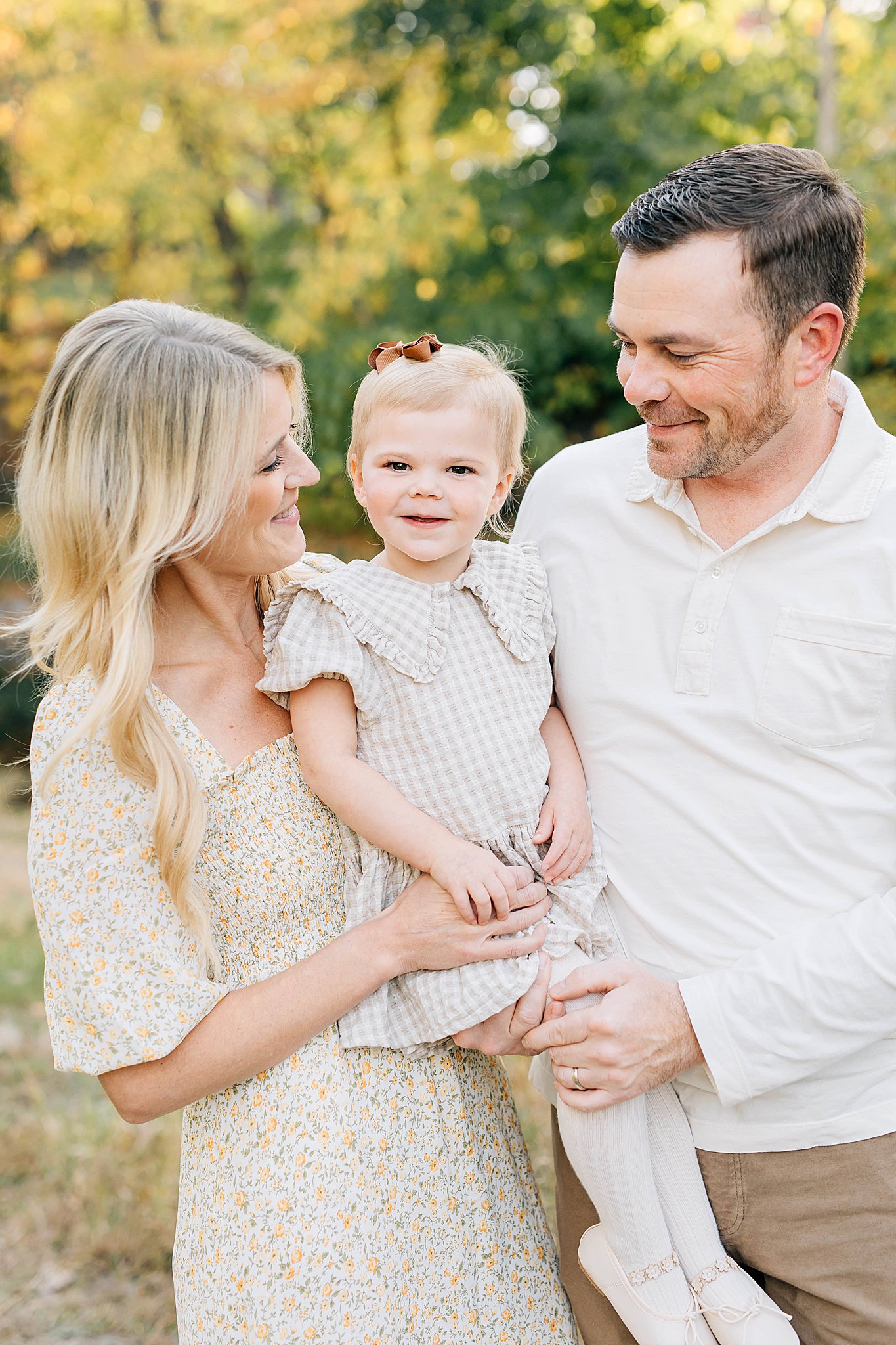Mom, child and dad smiling in 5 easy ways to prepare your kids for family photos.