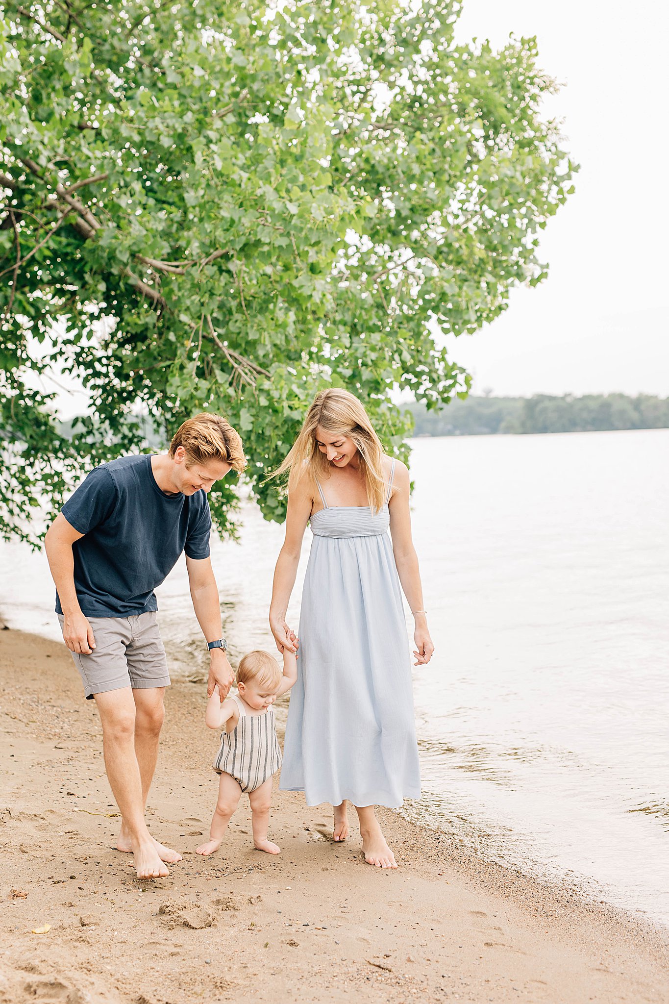 Dad and mom helping son walk on beach during ake Minnetonka Family Pictures.