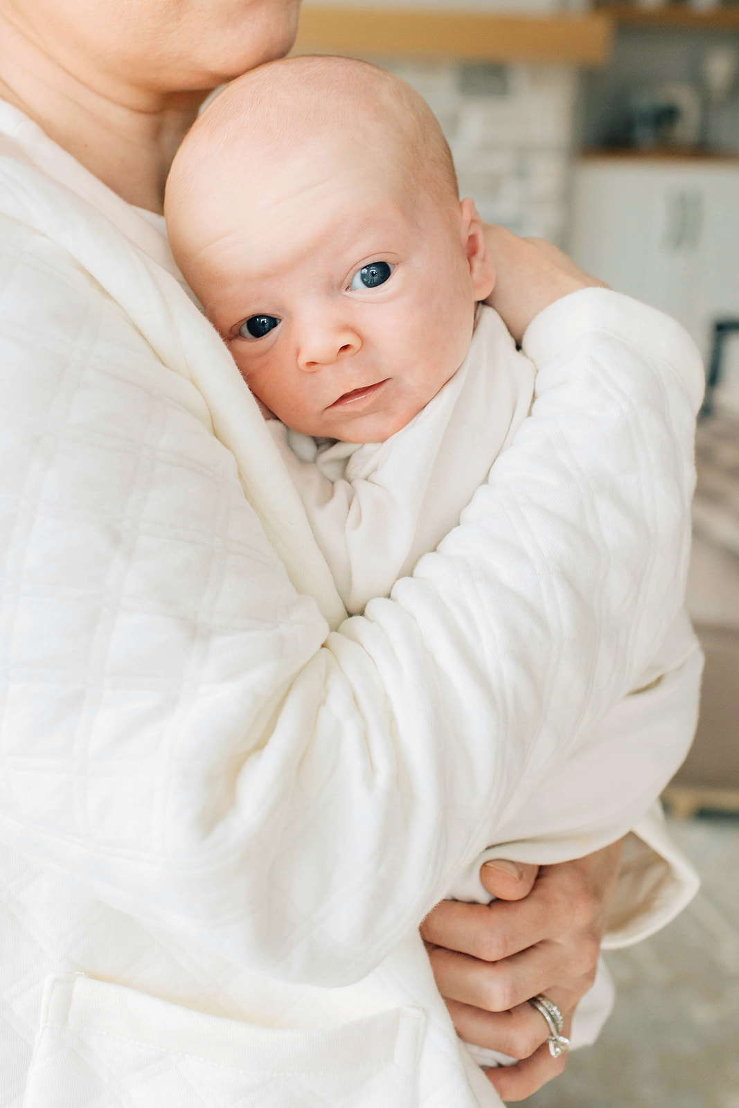 Newborn Baby Being Held by Mom at In Home Session