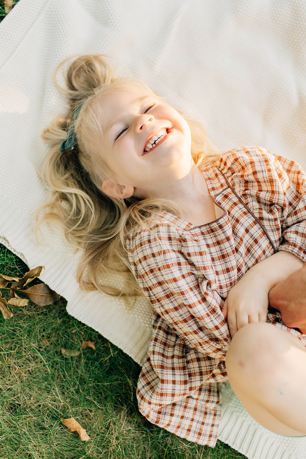 Little Girl Laughing and Having Fun with Parents During Family Photoshoot